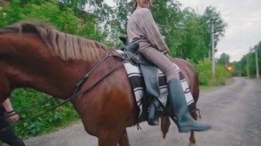 Neşeli genç kadın, geriye doğru ata biniyor