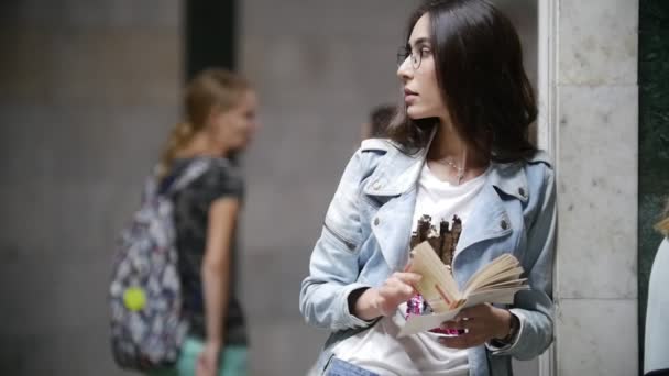 Chica con un libro esperando el tren del metro, cámara lenta — Vídeo de stock