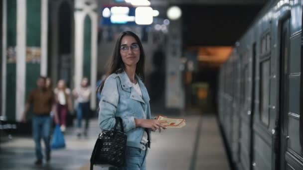 Дівчинка чекає на зупинку поїзда метро, повільний рух — стокове відео