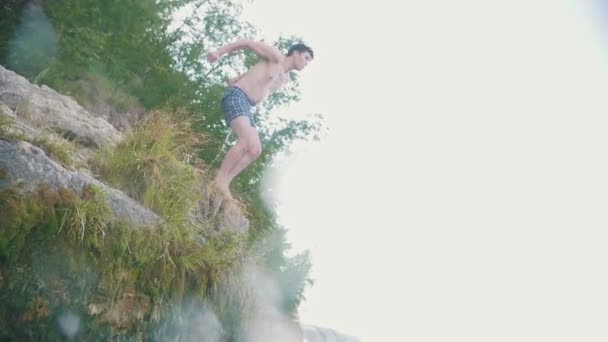 Молодой человек ныряет головой вниз в реку, замедленная съемка — стоковое видео