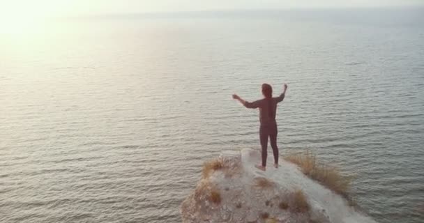 Junge Frau beim morgendlichen Aufwärmen auf felsiger Klippe am Fluss — Stockvideo