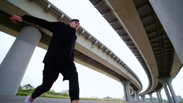 El hombre da la vuelta por debajo del puente, en cámara lenta — Vídeos de Stock