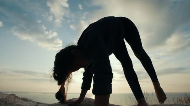 Mujer joven haciendo acro yoga en la gran piedra al amanecer — Vídeo de stock