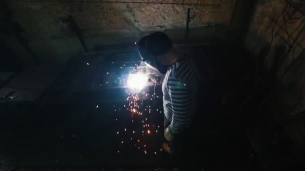 Чоловік на заводі зварює металеву решітку — стокове відео