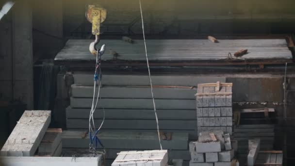 Металлические кабели на крючке закреплены для работы бетонного блока на производстве — стоковое видео