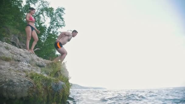 Человек делает трюк в прыжке в реку на отдых на природе, замедленная съемка — стоковое видео