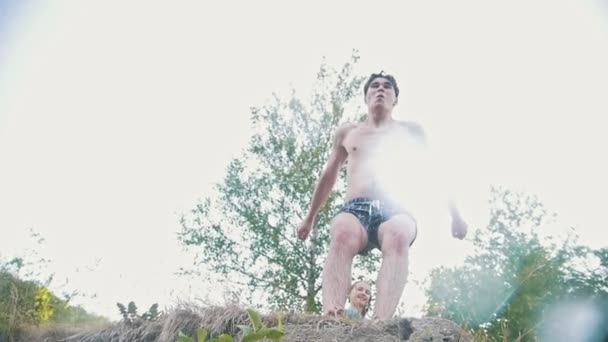 Killen gör hoppar i vattnet från en klippa, underifrån, Slowmotion — Stockvideo