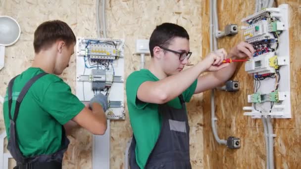 Twee tieners werken met elektrische apparatuur in werkplaats — Stockvideo