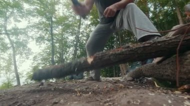 Kamp ateşi için yaz ormanda odun keserken dostum