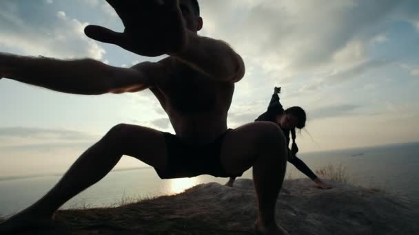 Jeune homme et femme faisant des exercices matinaux au lever du soleil — Video