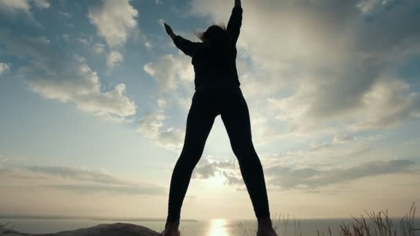 Weibliche Silhouette macht körperliche Bewegung gegen den Sonnenaufgang — Stockvideo