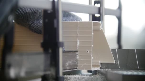 Мужская рука распиливает пластиковые детали в мастерской — стоковое видео