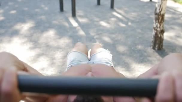 Muskulöser Mann schwingt die Bauchmuskeln auf der waagerechten Stange im Freien — Stockvideo