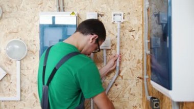 Genç öğrenci elektrikçi elektrik iletkenler atölyesi olarak yükler.