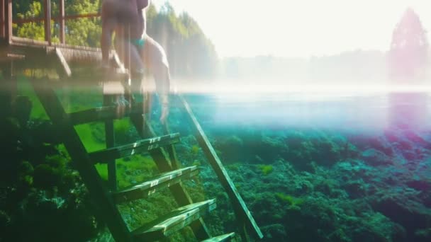 Joven hombre por las escaleras en el lago azul claro — Vídeo de stock