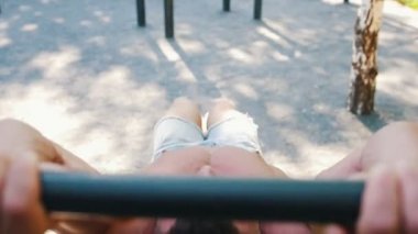 Kaslı adam salıncak karın kasları üzerinde yatay çubuk açık havada