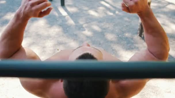Μυώδης άνδρας εκτελεί άσκηση σε εξωτερικούς χώρους οριζόντια γραμμή — Αρχείο Βίντεο