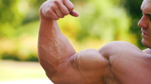 Onun büyük bicepses gösterilen güçlü kas adam atlet — Stok video