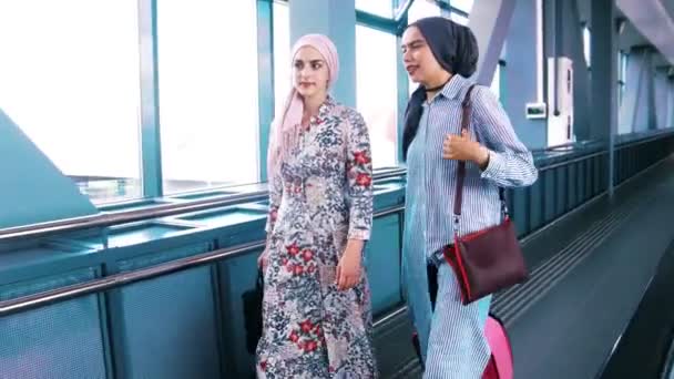 İki Müslüman kadın Havaalanı yürüyen merdiven üzerinde seyahat — Stok video