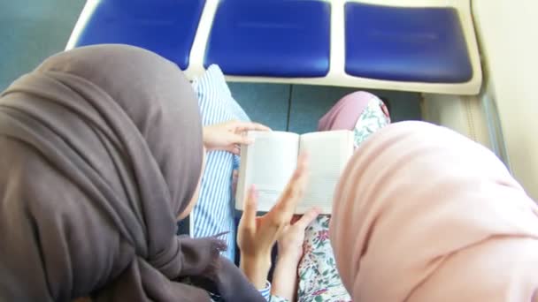 Две мусульманки читали книгу в поезде — стоковое видео