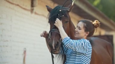 Mutlu genç kadın at başlığı için siyah at ahırda giyer.