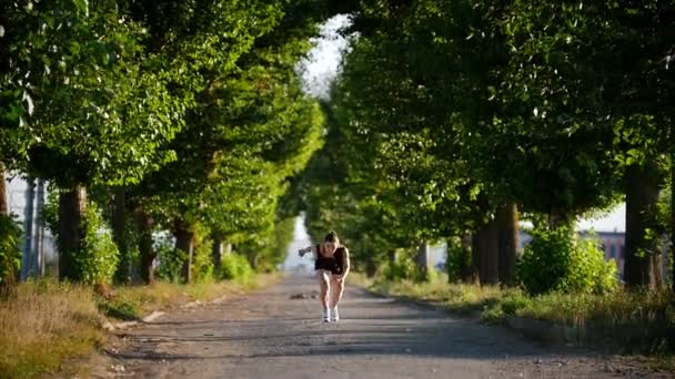 Jeune femme sportive courant dans le parc vert — Video