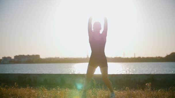 Sportieve vrouw treinen tegen de zon — Stockvideo