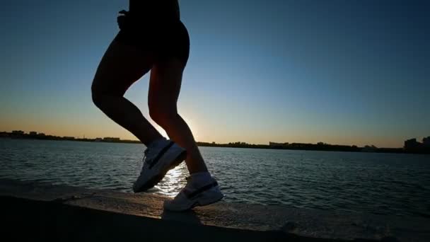 Спортивная молодая женщина бегает по набережной — стоковое видео