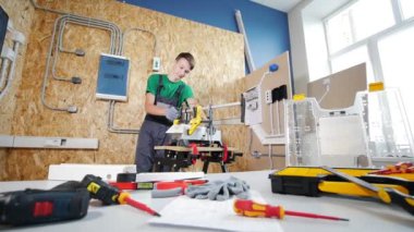 Ayrıntılar testere atölye çalışmasında, çalışan bir genç çocuk