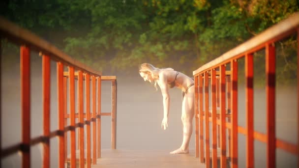 水着で若い女性が陸上競技を実践し、ダウンして手を取得します — ストック動画