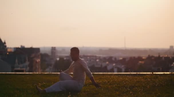 Starker athletischer Mann zeigt Tricks beim Capoeira-Tanz auf dem Rasen bei Sonnenuntergang — Stockvideo