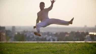 Yetenekli adam inanılmaz derecede karmaşık ve dik hareketler capoeira dövüş sanatının günbatımında yapar.