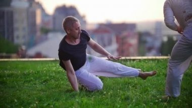 Erkekler tren, hareketleri yapmak Brezilya dansı Capoeira çimenlerin üzerinde yaz