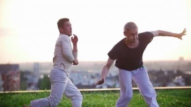 Yaz günbatımı güzel karşı çimenlerin üzerinde Capoeira dövüş ve savunma sanatı atletik erkek meşgul