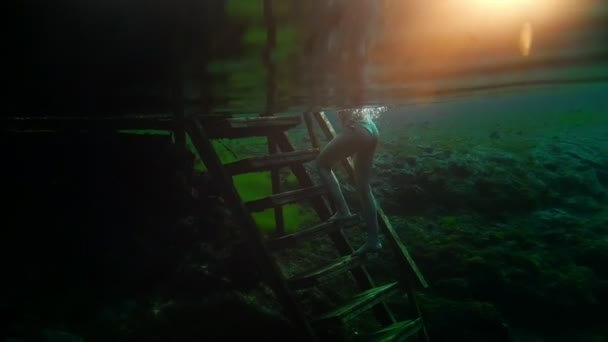 Hermosa chica sube las escaleras y sale del lago transparente — Vídeos de Stock