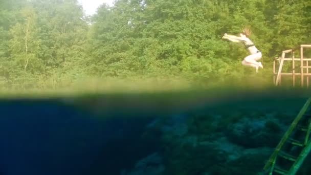 Jeune femme avec une course saute dans le lac — Video