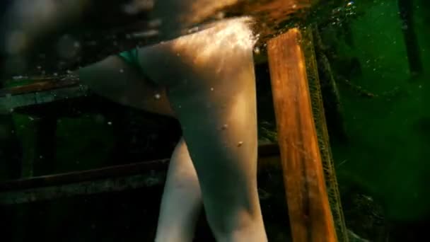 Menina se levanta sob a água nas escadas — Vídeo de Stock