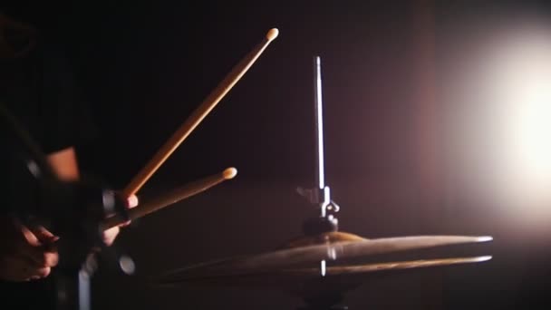 女性の手が暗闇の中で棒で太鼓を打ち鳴らす — ストック動画