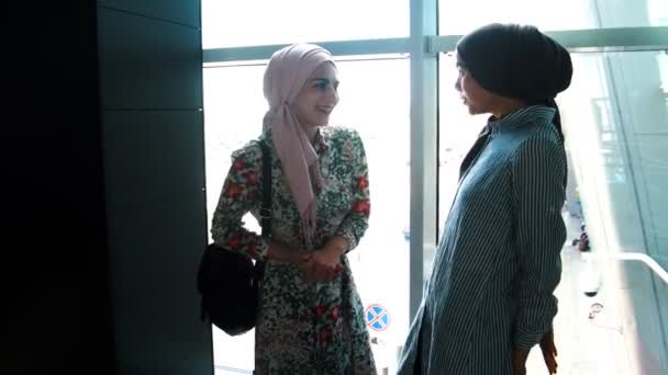 Les filles musulmanes attendent aeroexpress et parlent à côté des fenêtres panoramiques — Video