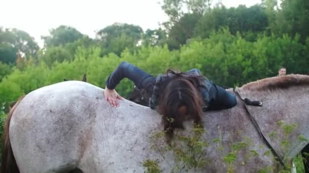 Молодая спортсменка садится на лошадь и отправляется на прогулку с друзьями — стоковое видео