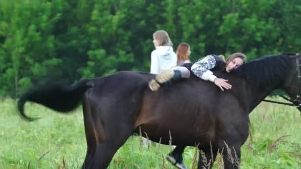 Dívka rider šplhá na koně a jiná dívka na koni zaslány po okraji lesa — Stock video