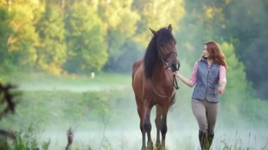 Doğada bir atı ile yürüyen genç kadın