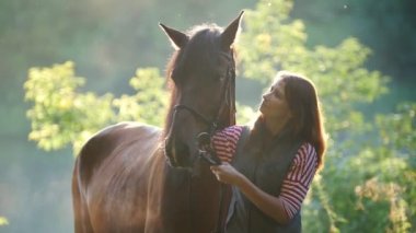 Sarılma ve bir at ormanda şafakta okşayarak genç kadın