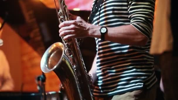 Músico-saxofonista tocando um instrumento em uma festa em um bar de jazz no quadro apenas suas mãos — Vídeo de Stock