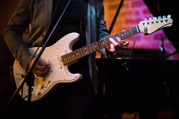 Unknown musician plays guitar at a party in a jazz bar