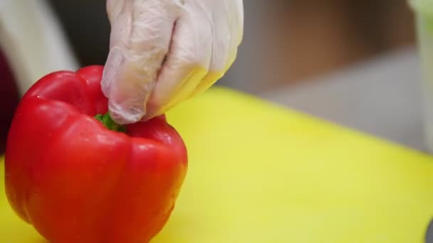 Cook škrty červenou paprikou na žluté desky, v rámci rukou kuchaře — Stock video