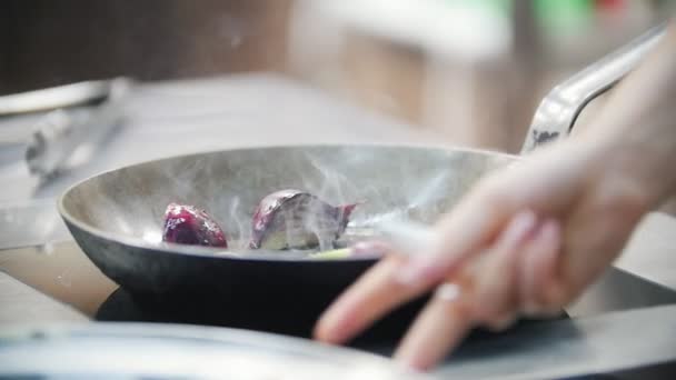 Cocinar se dedica a trozos calientes de cebolla en una sartén, en el marco de la mano de los chefs — Vídeo de stock