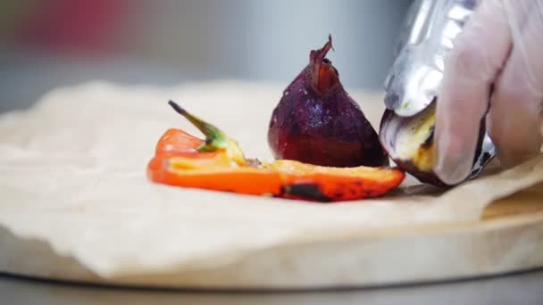 Cocinar sobre pergamino pone verduras cocidas: cebolla, pimiento rojo, espárragos, tomates cherry — Vídeo de stock