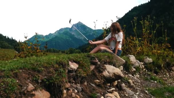 Menina bonita atira em si mesma na câmera do smartphone no fundo da natureza incrível — Vídeo de Stock