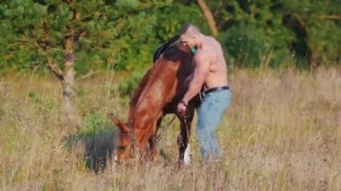 Onun yele alanında bir güneşli yaz gününde çizilmemesi at, yanındaki çömelme genç sporcu